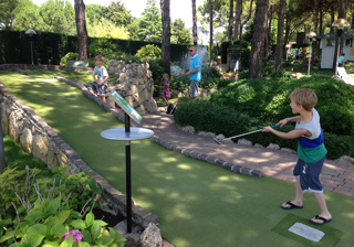 Boy playing golf ball up the hill